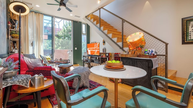 A modern living room with a dining area, a staircase, and a large window. - Industrial Luxury Updated condo, 5 mins to Railyard, 7 mins to Plaza (Santa Fe)