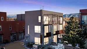 A modern building with a flat roof, large windows, and a metal staircase leading to the entrance. - Industrial Luxury Updated condo, 5 mins to Railyard, 7 mins to Plaza (Santa Fe)