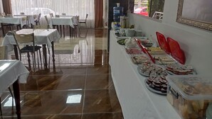 Una mesa de buffet con diferentes alimentos y un dispensador de agua.