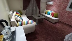 Un espacio habitable pequeño con un sofá, una mesita y una pared con diseño.