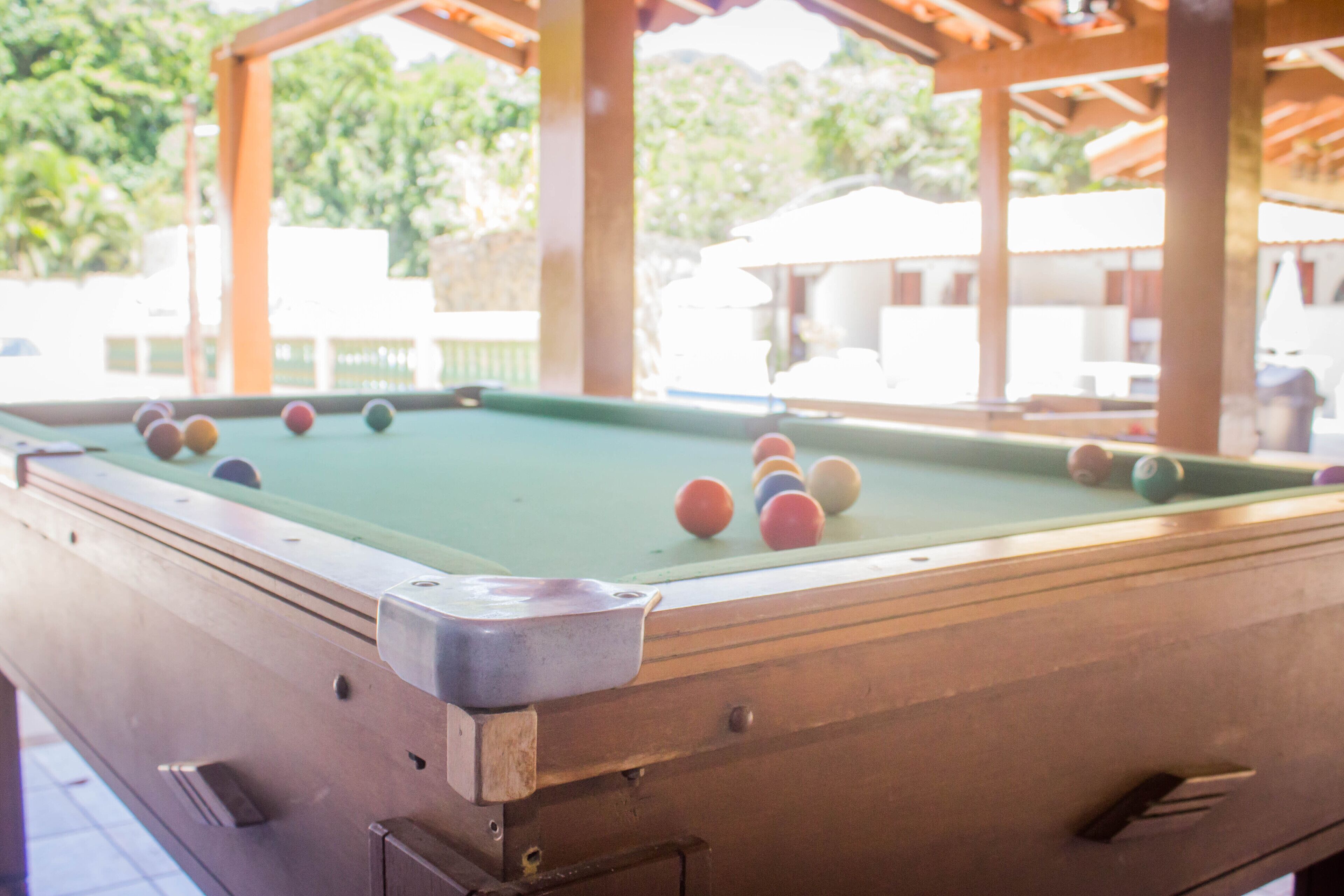 A pool table with balls, wooden beams, and a metal frame.