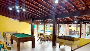 Un espace de loisirs équipé de tables de billard, d’une table de baby-foot et d’une table de billard.