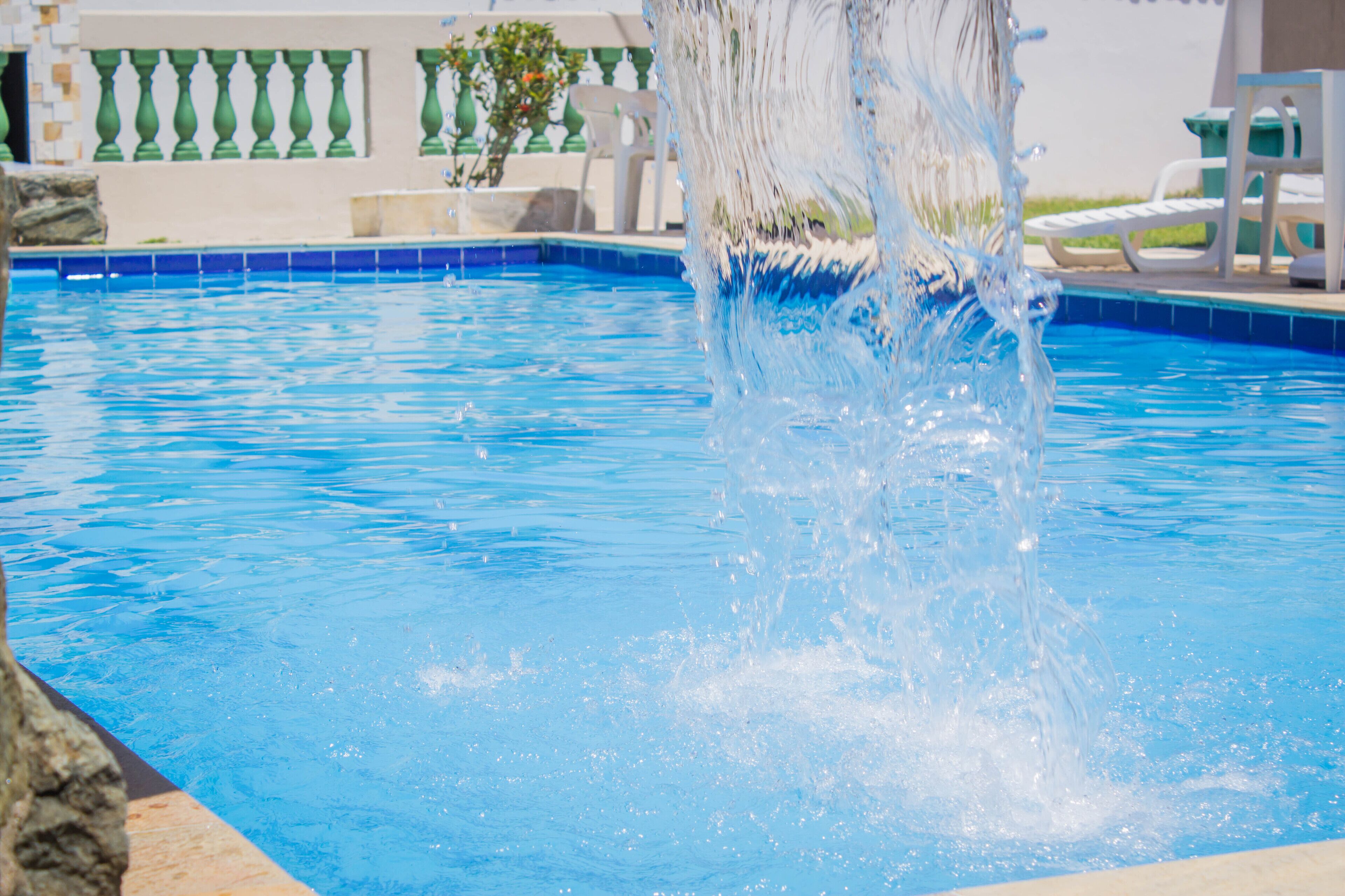 A clear view of a swimming pool with a water fountain feature.