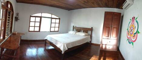 A bedroom with a wooden bed, a window, and a door.