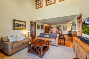 A spacious living room with two sofas, a coffee table, and a dining area with chairs. - Bear Claw 614 Premium On Mountain Condo with Ski-In/Ski-Out Access! (Steamboat Springs)