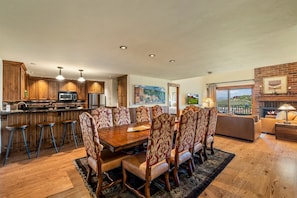 Un salon spacieux avec une grande table à manger en bois, des chaises assorties et une cheminée.