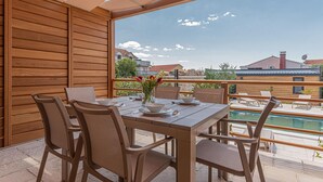 An outdoor dining area with a wooden table and chairs, a view of a swimming pool, and a clear sky. - Gorgeous home in Brodarica (Brodarica)