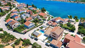 A coastal residential area with houses, a road, and a clear view of the sea. - Gorgeous home in Brodarica (Brodarica)