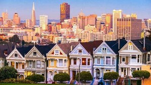 Una hilera de casas de estilo victoriano con el perfil urbano al fondo.