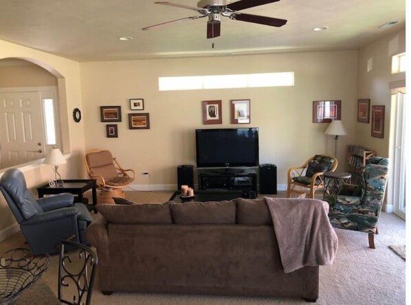 A living room with a brown sofa, two armchairs, a TV, and a ceiling fan. - C24 home by pool & Gorge shuttle (Quincy)