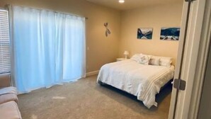 A bedroom with a bed, a nightstand, a window with curtains, and a wall-mounted picture. - D28-ATCH Garage 2 Decks/Patio Sunserra Gorge AMP (Quincy)