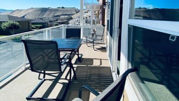 A covered outdoor area with a table and chairs, overlooking a landscape with hills. - D28-ATCH Garage 2 Decks/Patio Sunserra Gorge AMP (Quincy)