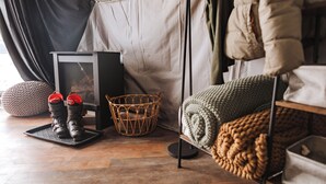 A cozy room with a bed, a small table, a basket, and a heater. - Tammah Jackson Hole (Wilson)
