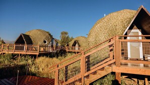 A series of dome-shaped cabins with wooden walkways and a central building with a door. - Tammah Jackson Hole (Wilson)