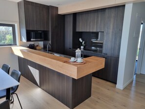 Superior appartement | Privékeuken | Een koelkast met diepvriezer, een microgolfoven, een oven, een kookplaat