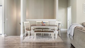 Un espace repas comprenant une table et des chaises, un banc, un tapis et un canapé.