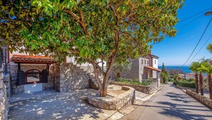 A narrow street with stone buildings, a stone bench, and a view of the sea. - Amazing home in Icici with WiFi (Icici)