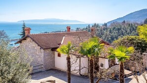 A stone building with a tiled roof overlooking a coastal area, surrounded by trees and hills. - Amazing home in Icici with WiFi (Icici)
