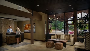 A reception area with a reception desk, a sofa, and a coffee table. - Premiere Suite With Access to Pools, Hot Tub, Spa (Bend)