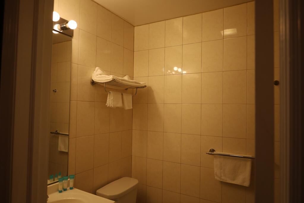 A bathroom with a toilet, a sink, and a towel rack.