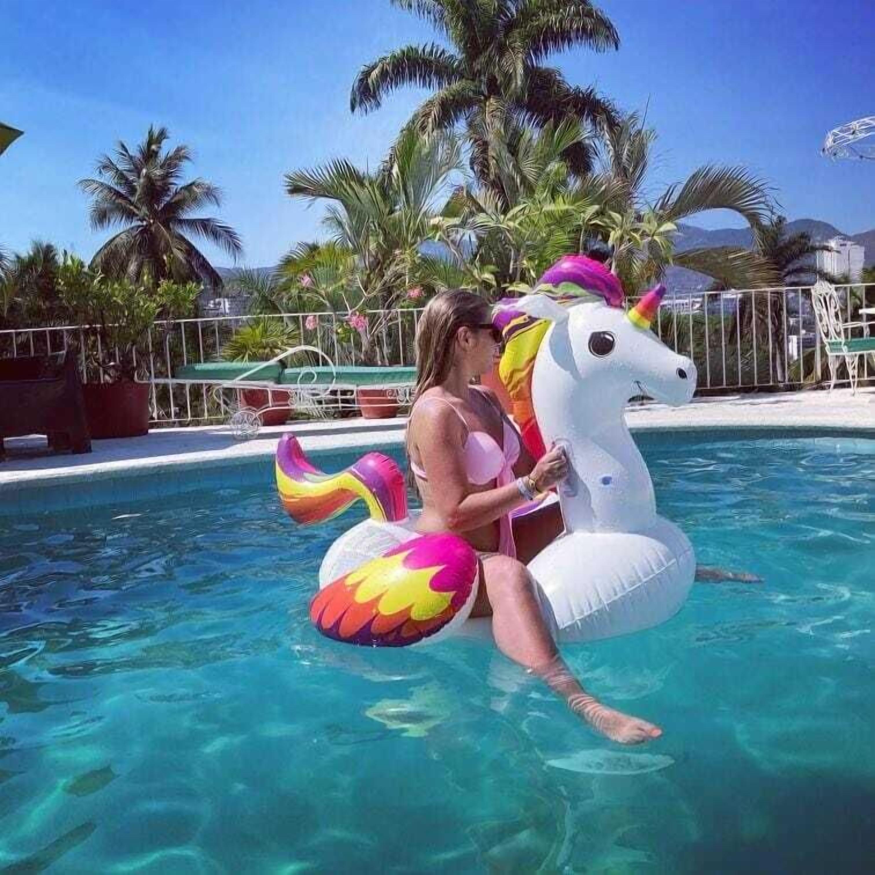 Une personne dans une piscine, sur un flotteur en forme de licorne.
