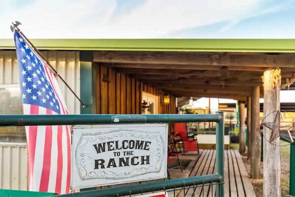A rustic wooden building with a sign that reads "WELCOME TO THE RANCH".