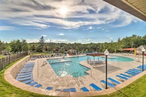 Relax by the pool surrounded by lounge chairs and a shallow area with steps leading down to the water.