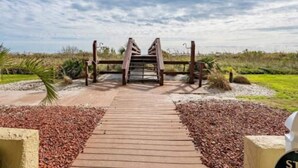 Un sendero de madera que conduce a una entrada con portón.