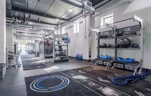 A gym with weightlifting equipment, a pull-up bar, and a mat with a logo. - Buckhead Loft Near Stadium & Piedmont Hospital (Atlanta)