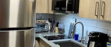 Een koelkast, een magnetron, een kookplaat, een vaatwasser