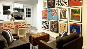 Una sala de estar moderna con comedor, y una cocina al fondo.