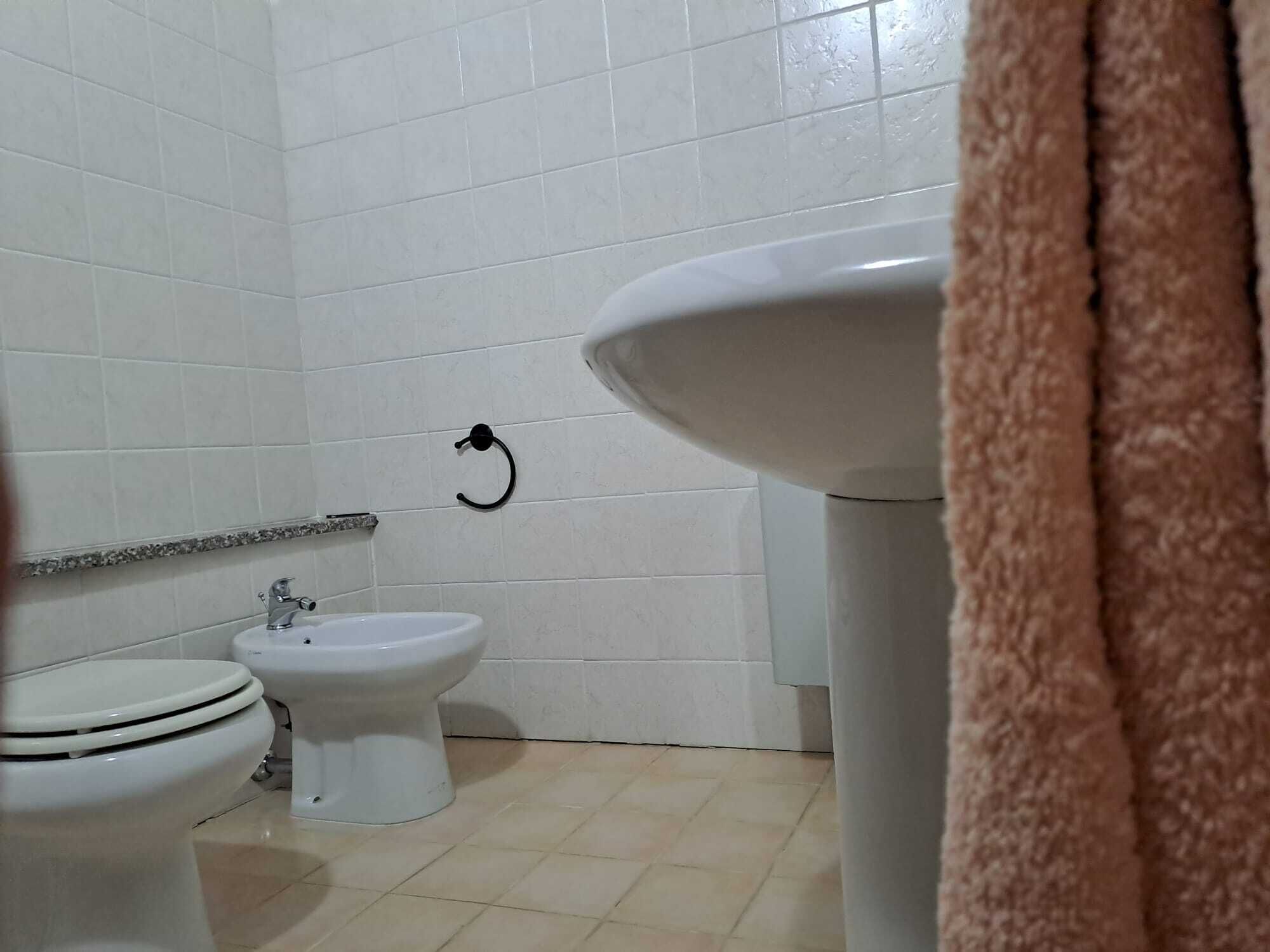 A bathroom with a toilet, bidet, and sink.