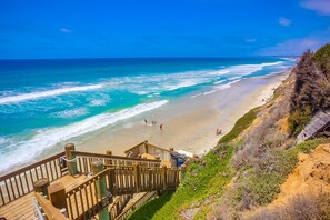 A beach with a wooden staircase leading down to the shore, a sandy beach, and the ocean. - Ocean+Sunset Views * 3 Levels * 5 Outdoor Areas (Encinitas)