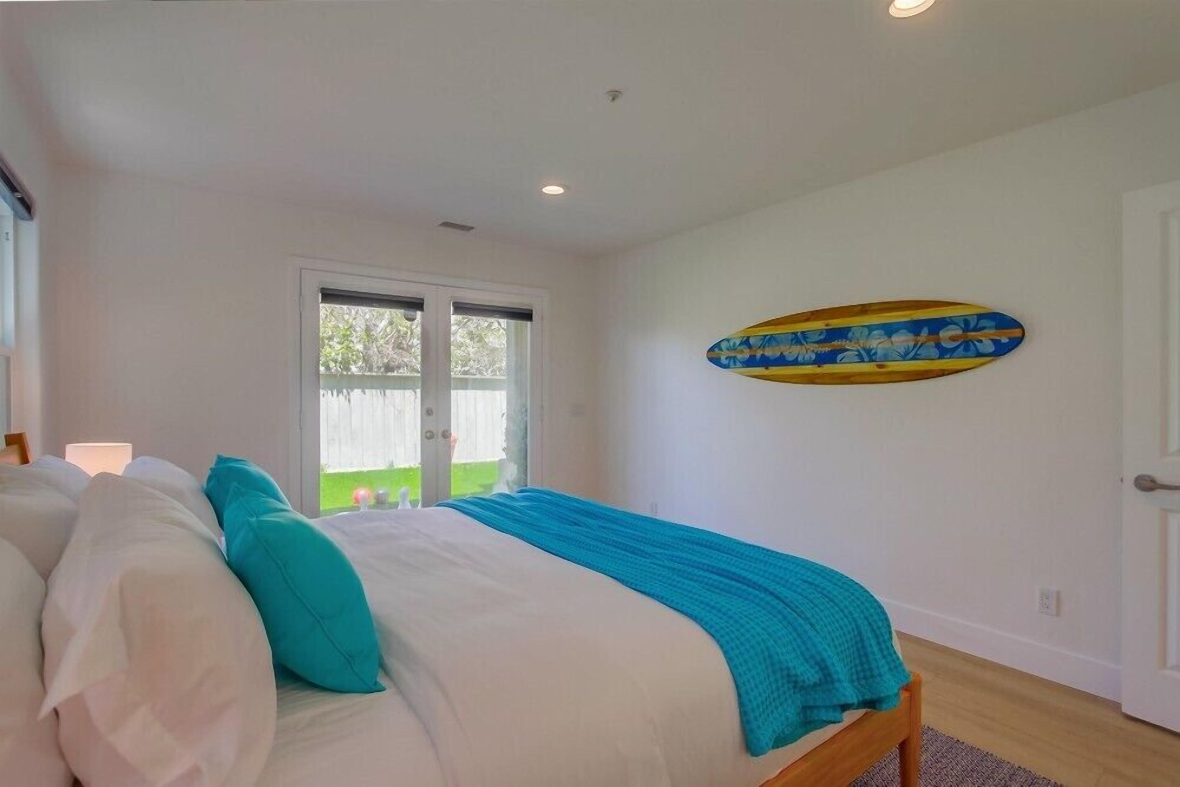 Quarto com cama, janela e porta.