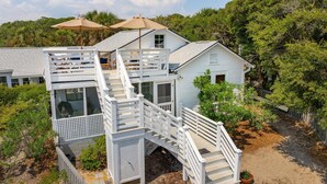 A white house with a wooden deck and a staircase leading to a balcony. - Sandcrab - Quaint Ocean View Cottage, Beach Access Directly Across (Folly Beach)