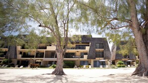 Ein Resort mit mehrstöckigen Gebäuden, Außenbereichen zum Sitzen und einem Sandhof.