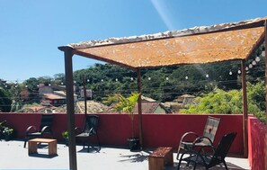 Une terrasse sur le toit, dotée d’un espace extérieur aménagé, d’une pergola et offrant une vue sur le quartier environnant.