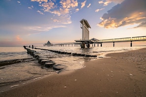 A pier extending into the water with a viewing platform and a tall structure at the end.