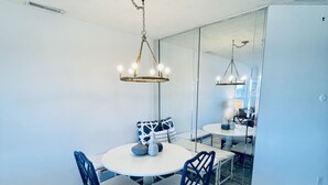 Ein Essbereich mit einem runden Tisch, Stühlen und einer Chandelüster.