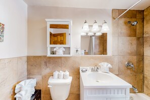 Features a sleek vanity, separate shower area, and storage cabinet.