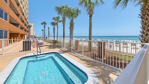 Ein Poolbereich mit Blick auf den Strand und Palmen.