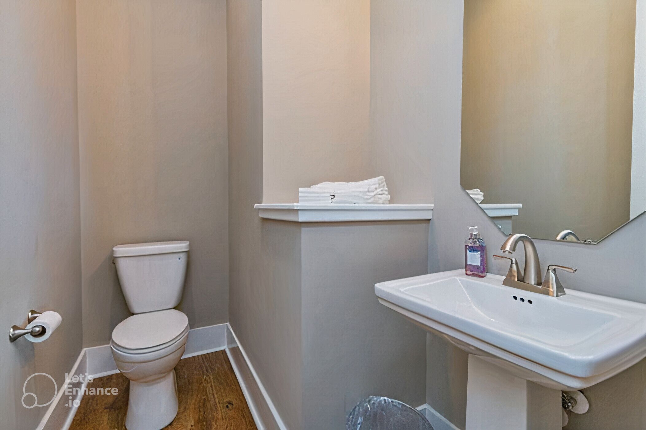 A small bathroom with a toilet, sink, and mirror.