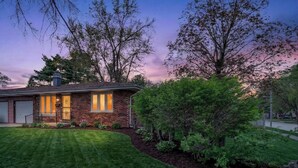 A residential house with a brick exterior, a front porch, and a well-maintained lawn. - Spacious & Cozy ~ Mins to Downtown (Springfield)