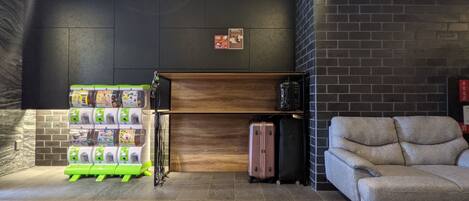 Un vestíbulo moderno con zona de estar, máquina expendedora y estante de pared.