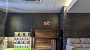 A modern lobby with a brick wall, a wooden cabinet, and a seating area. - ESLEAD HOTEL Namba Ebisu West (Osaka)