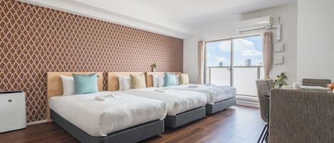A hotel room with a modern design, featuring a large bed with multiple pillows, a small desk, and a view through a sliding glass door.