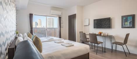Una habitación de hotel moderna con cama, zona de estar y escritorio.
