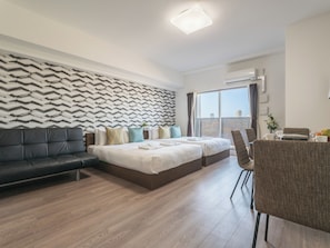 Une chambre d’hôtel moderne dotée d’un grand lit, d’un canapé, d’un coin repas et offrant une vue sur la ville.
