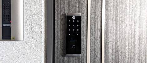 A modern elevator with a keypad and a card reader, mounted on a textured wall.