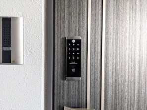 Un ascensor moderno con teclado y lector de tarjetas, instalado en una pared con textura.